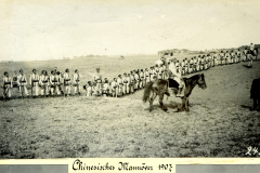 Chinesisches Manöver im Jahr 1907 mit Soldaten auf dem Feld und einem Reiter in traditioneller Kleidung