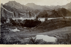 Die Große Mauer in China mit umliegenden Bergen, Wasser und Vegetation während des frühen 20. Jahrhunderts