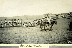 Chinesisches Manöver im Jahr 1907 mit Soldaten auf dem Feld und einem Reiter in traditioneller Kleidung
