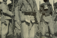 Chinesischer Soldat steht mit Gewehr in traditioneller Uniform auf einem Feld während des Manövers