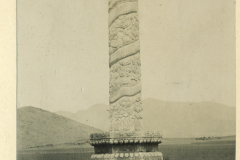 Die beeindruckende China-Säule am Eingang zur Tierallee bei klarem Himmel und sanften Hügeln im Hintergrund
