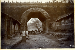 Altes Tor bei Schol in China mit historischen Gebäuden und vorbeiziehenden Tieren