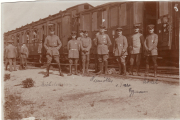 Soldaten stehen vor einem Zug in einer historischen Militärstation