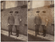 Zwei Soldaten in Uniform neben einer Mauer vor einem historischen Gebäude