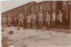 Soldaten stehen vor einem Zug in einer historischen Militärstation