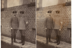 Zwei Soldaten in Uniform neben einer Mauer vor einem historischen Gebäude