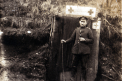 Ein Soldat steht vor einem Rotkreuz-Medizintent im Ersten Weltkrieg