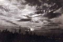 Gewölkter Himmel über einem Wald bei Sonnenuntergang im Herbst