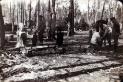 Arbeiter im Wald beim Holzverarbeiten unter Bäumen in den frühen 20er Jahren