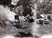 Ein Mann sitzt im Wald und kocht über einem Lagerfeuer