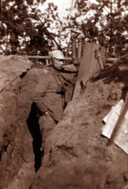 Ein Soldat steht in einem Schützengraben während des Ersten Weltkriegs