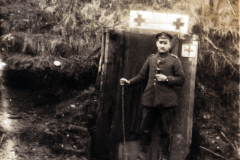 Ein Soldat steht vor einem Rotkreuz-Medizintent im Ersten Weltkrieg