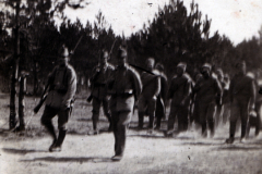 Soldaten marschieren durch einen Waldweg im frühen 20. Jahrhundert