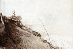 Steiles Flussufer mit wenig Bewuchs in historischer Landschaft