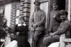 Vier Personen stehen vor einem historischen Gebäude in der Vergangenheit