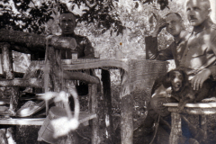 Drei Männer sitzen bei einem Picknick im Wald mit einem Hund, 1940er Jahre