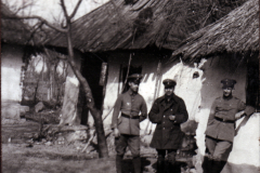 Soldaten vor einem beschädigten Gebäude im ländlichen Kriegsgebiet
