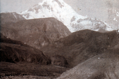 Schneebedeckter Berg mit umliegenden Hügeln in der Ferne bei Tageslicht