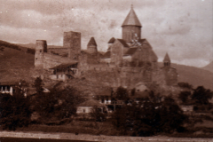 Historische Burg auf einem Hügel mit umliegendem Dorf in der Dämmerung