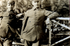 Soldaten lehnen entspannt an einem Zaun, 1915, ländliche Umgebung