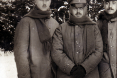 Drei Soldaten stehen in Winteruniform in einer verschneiten Landschaft