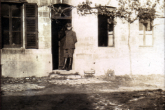 Soldat steht an der Tür eines alten Hauses in einer ländlichen Gegend