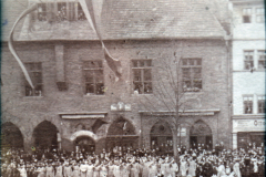Festumzug vor dem Rathaus in einer historischen Stadt um 1900