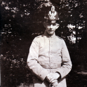 Ein junger Soldat in historischer Uniform steht vor einem Baum im Park