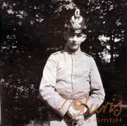 Ein junger Soldat in historischer Uniform steht vor einem Baum im Park