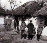 Soldaten vor einem beschädigten Gebäude im ländlichen Kriegsgebiet