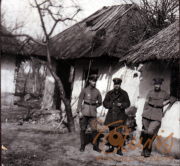 Soldaten vor einem beschädigten Gebäude im ländlichen Kriegsgebiet