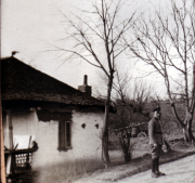Ein Soldat steht vor einem alten Haus in ländlicher Umgebung im Frühling
