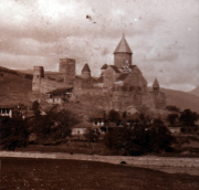 Historische Burg auf einem Hügel mit umliegendem Dorf in der Dämmerung