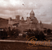 Historische Burg auf einem Hügel mit umliegendem Dorf in der Dämmerung