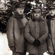 Drei Soldaten stehen in Winteruniform in einer verschneiten Landschaft