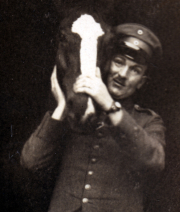 Ein Soldat hält ein Tierkopf in der Hand während des Ersten Weltkriegs