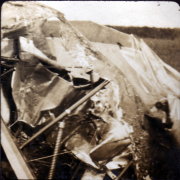 Überreste eines beschädigten Flugzeugs auf einem Feld in ländlicher Umgebung