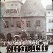 Festumzug vor dem Rathaus in einer historischen Stadt um 1900