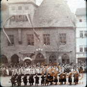 Festumzug vor dem Rathaus in einer historischen Stadt um 1900