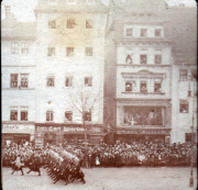 Historischer Militärumzug auf einer Stadtstraße mit Zuschauern im Jahre 1920