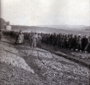Menschenmenge steht auf einem Feld in der Dämmerung während des Krieges