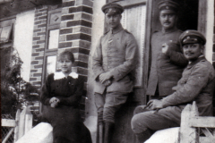 Vier Personen stehen vor einem historischen Gebäude in der Vergangenheit