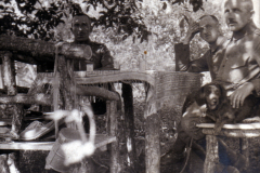 Drei Männer sitzen bei einem Picknick im Wald mit einem Hund, 1940er Jahre