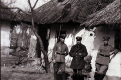 Soldaten vor einem beschädigten Gebäude im ländlichen Kriegsgebiet