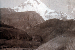 Schneebedeckter Berg mit umliegenden Hügeln in der Ferne bei Tageslicht