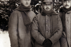 Drei Soldaten stehen in Winteruniform in einer verschneiten Landschaft