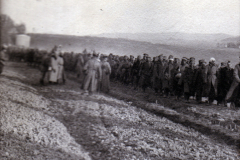 Menschenmenge steht auf einem Feld in der Dämmerung während des Krieges