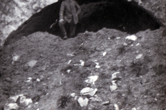 Mann steht vor einem historischen Steinbogen in den Bergen