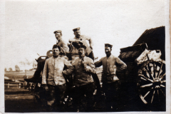 Soldaten posieren stolz vor einem historischen Militärfahrzeug im Freien
