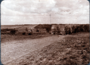 Landschaft mit Feldweg und Hügeln in ländlicher Umgebung während des Tages